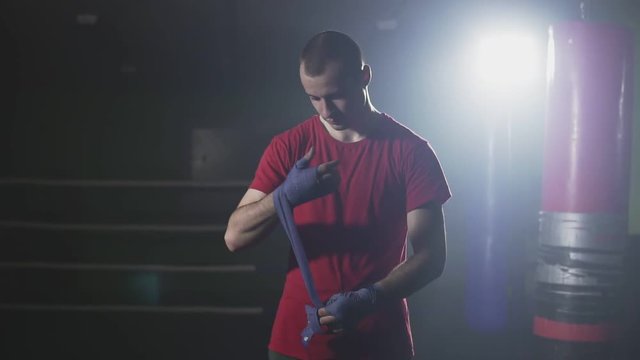 Kickboxer wapping hands getting ready for fight in slow motion.