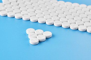 Pills tablets capsules closeup. On a blue background, a jar of medicine.