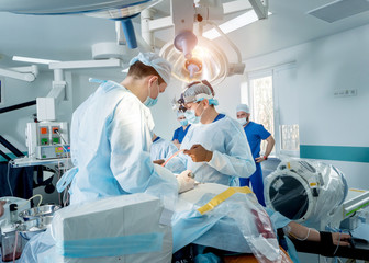 Spinal surgery. Group of surgeons in operating room with surgery equipment. Laminectomy