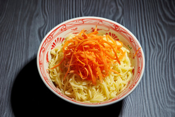 Shredded carrot on boiled yellow noodle