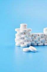 Pills tablets capsules closeup. On a blue background, a jar of medicine.