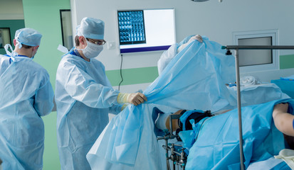 Arthroscope surgery. Orthopedic surgeons in teamwork in the operating room with modern arthroscopic...