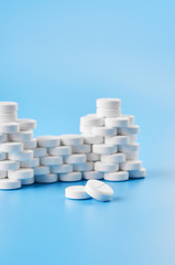 Pills tablets capsules closeup. On a blue background, a jar of medicine.