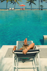 Beautiful woman relaxing in a pool at summer