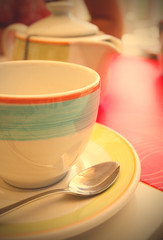 tea cup with a spoon of sugar on table