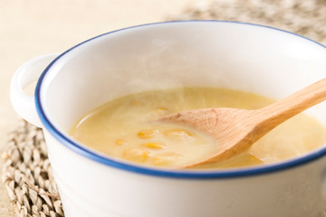 ほんのり湯気の立つ、スプーンですくったコーンクリームスープ