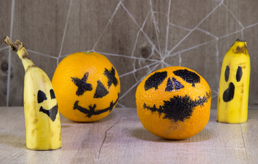 Jack lantern for Halloween of oranges on a wooden background with cobwebs.