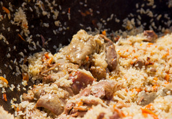 cooking delicious pilaf in a cauldron in the fresh air