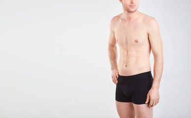 Fototapeta premium A man in black underwear on a gray background.