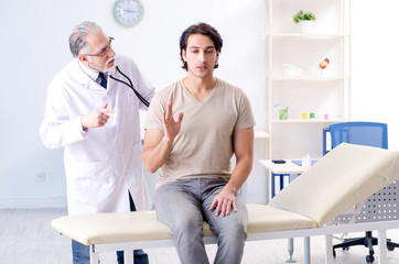 Obraz premium Young male patient visiting old doctor 