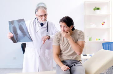 Fototapeta premium Young man visiting old male doctor radiologist 