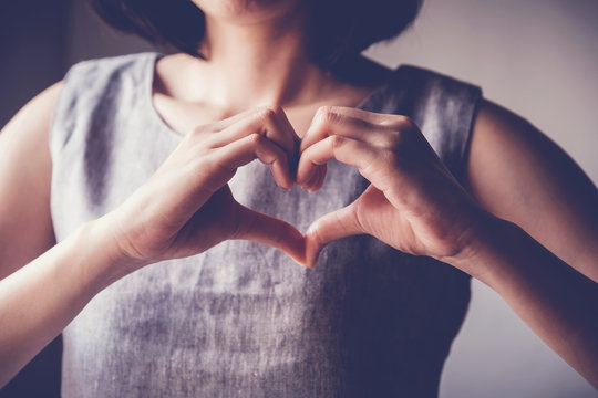 young woman making her hands in heart shape, heart health insurance, social responsibility, donation charity, world heart day, appreciation, world mental health day, stop Asian hate concept