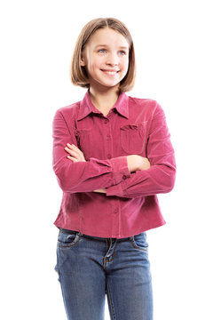 Cute smiling teen girl in a pink shirt and jeans is standing. Isolated on a white background. Vertical.