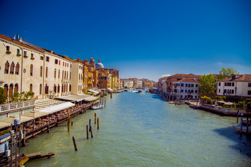 View of the Grand Canal in Venice. On both sides of the canal house, in the distance you can see the dome of the Church. In the distance the channel sailing boats and motor boats