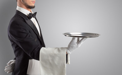 Waiter serving with white gloves and steel tray in an empty space
