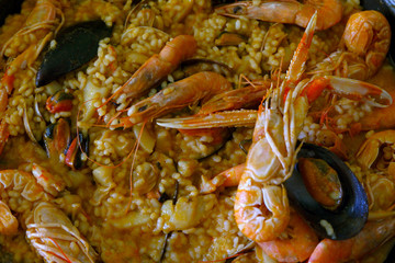 Closeup of homemade paella - a traditional Spanish rice (bomba variety) dish with seafood: shrimps, langoustines, sepia and mussels. Characteristic for the regions - Valencia, Catalonia and Andalusia