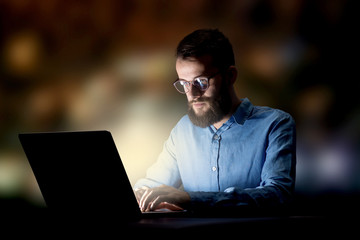 Young handsome businessman working late at night in the office