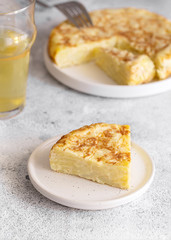  Tortilla,  Spanish omelette made with eggs and potatoes. Traditional Spanish tapa served with slices of jamon, Iberian ham on white background.