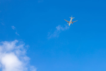 Airplane in the blue sky. Airliner is gaining altitude. White cloud in the blue sky in which the plane flies.
