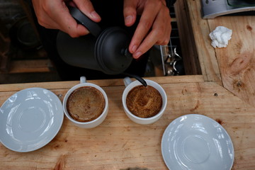 coffee brewing, step by step. Barista gently pours hot water on the surface of the ground coffee. Wetting the coffee