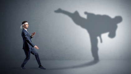 Young karate man confronting with his own shadow
