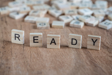 the word ready written with cube letters on wood