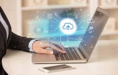 Business woman in homey environment using laptop with  online storage and cloud technology concept
