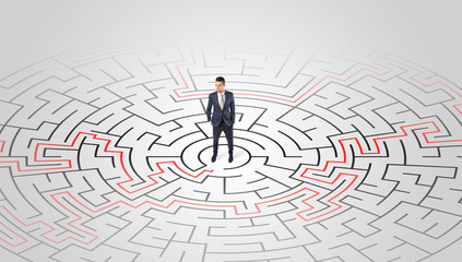 Young entrepreneur standing in a middle of a labyrinth with the solution
