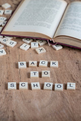 Fototapeta na wymiar back to school template with cube letters and book on table