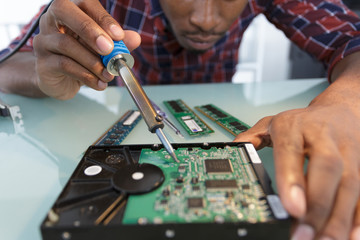 close-up of a man soldering a chip in a workshop