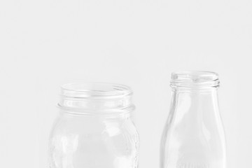 Glassware crystal bottle mason jar on white wall background. Reusable materials plastic-free alternatives zero waste environmental protection food storage concept. Mockup poster with copy space