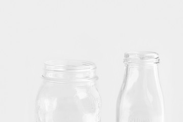 Glassware crystal bottle mason jar on white wall background. Reusable materials plastic-free alternatives zero waste environmental protection food storage concept. Mockup poster with copy space