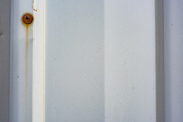 Rusty screw in a corrugated fence