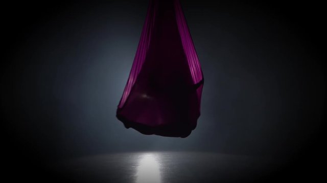 Woman aerial gymnast performing on violet silk in circus stage. Exciting acrobatic show 064