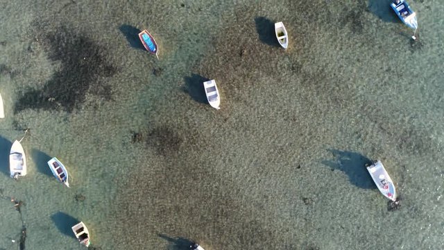 Aerial top down view flight over shallow bay with small recreational boats for anchor typical Mediterranean ocean scene located near the city of Trapani Sicily Italy 4k high resolution footage