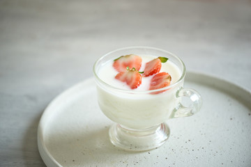 fresh organic yogurt with strawberries on table