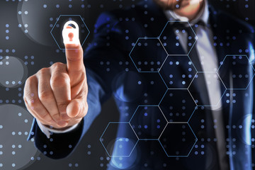 Businessman touching empty virtual screen against dark background, focus on hand