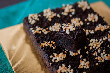Chocolate Cake Brownie Squares Drizzled With Chocolate Nutella and Walnuts. Closeup view, selective focus