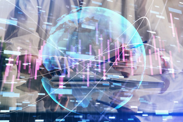 Financial forex graph drawn over hands taking notes background. Concept of research. Double exposure