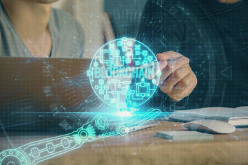 Crypto currency theme hologram with businessman working on computer on background. Concept of...