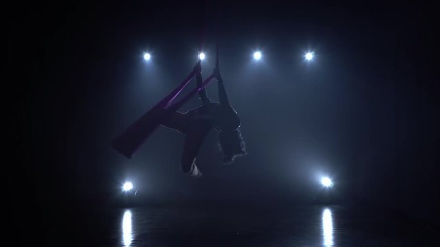 Girl aerial gymnast performing on a silk in a circus stage. Exciting acrobatic show. 075