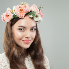 Naklejka premium Pretty smiling woman with clear skin, long shiny hair and flowers. Beautiful face close up