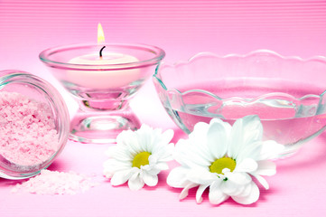 Obraz na płótnie Canvas wellness, spa and body care concept with pink candle, fresh water, white daisy flower over pink background 