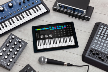 Piano synthesizer app on tablet and musical instrument concept
