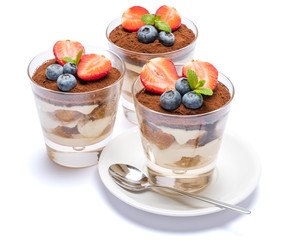 Classic tiramisu dessert with blueberries and strawberries in a glass isolated on a white background with clipping path