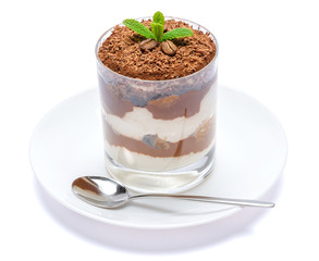 Classic tiramisu dessert in a glass on plate with spoon isolated on a white with clipping path
