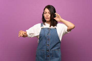 Young Mexican woman over isolated background listening to music with headphones