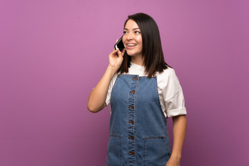 Young Mexican woman over isolated background using mobile phone