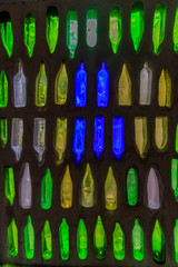 Wall with a green, yellow, white and blue glass bottle