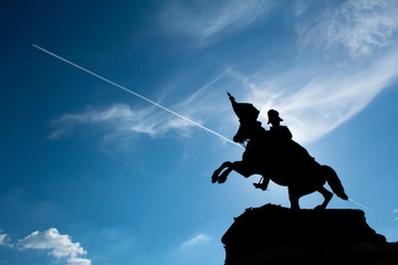Statue in Vienna with Plane in the background. A silhouette shot in Austria.